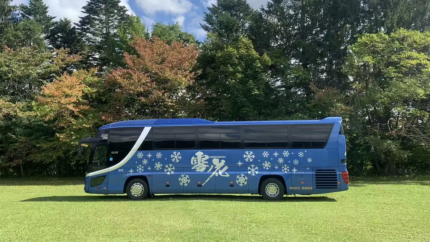 芝生の上に止まる大型バス（側面）